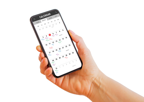 Person holding phone with calendar app on the screen on a white background