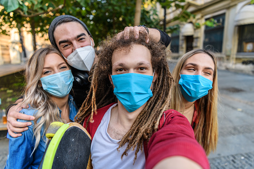 A Men with a Girfriends are Walking in the City District and Sharing Lovely Emotions While Taking Selfie Photos with a Mobile Phone in the Time of Corona Virus.