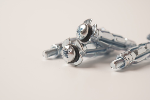 Zinc plated steel molly bolts. Four Molly metal dowels designed for fixing constructions isolated on a white background.