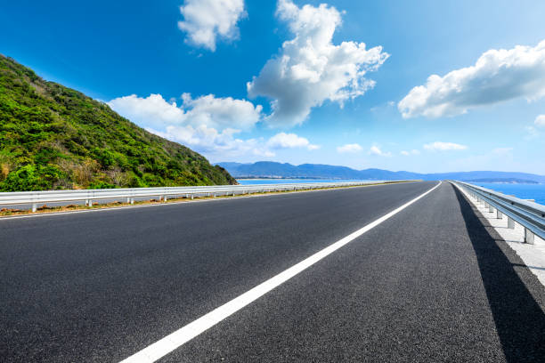 istock Mountain highway with blue sky and sea landscape. 1320105897