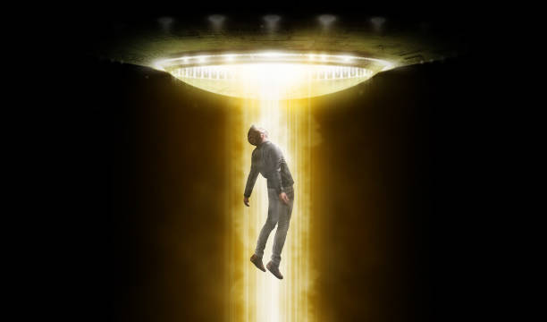 Man being abducted by UFO - alien abduction concept stock photo