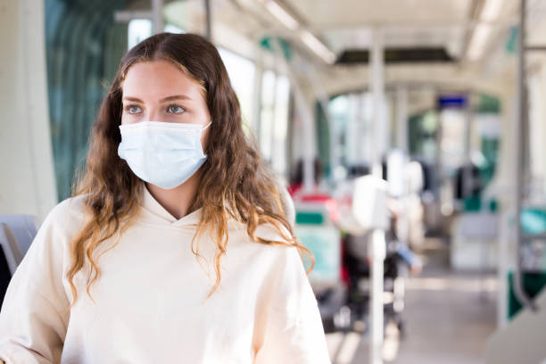 istock Young lady in face mask riding on tram to her work 1320106850