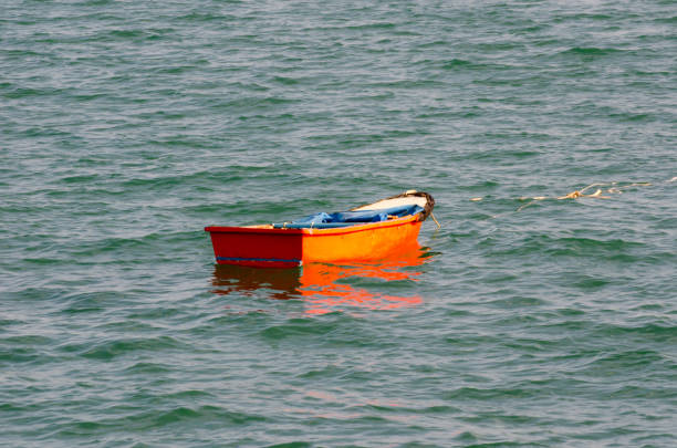 istock Small red boat in the water close to the beach 1320107052