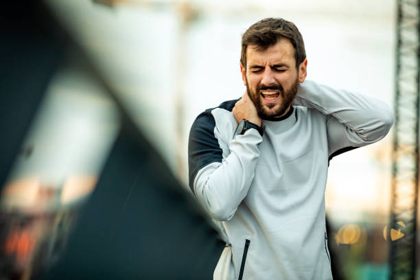 istock Young Athlete is Having Neck Problems while Jogging in the City 1320107106