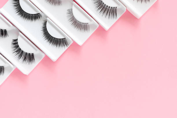 istock Different false eyelashes on a trendy pastel pink background. Beauty pattern. Makeup accessories. Cosmetics products for women. Top view, flat lay. Place for text. Layout. Сloseup. Copy space. 1320107180