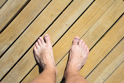 top view of male legs over wooden beach road