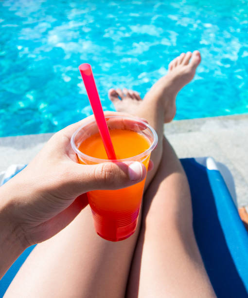 istock summer vacation concept - legs and cocktail over swimming pool background 1320111137