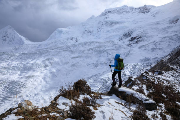 istock Successful woman backpacker hiking in winter mountains 1320112489