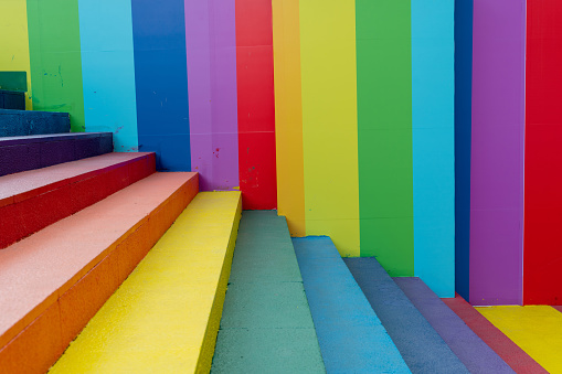 Multicolored painted concrete fence  surrounding a children playground, close-up full frame front view.