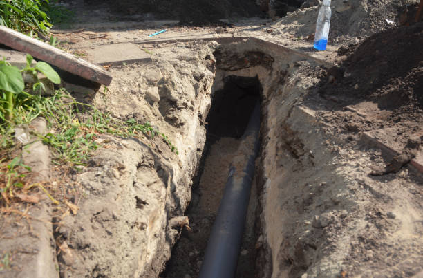 istock Installing underground downspout drain line, sewer line or waste pipe in a trench. Laying pvc pipeline in a deep trench. 1320113433
