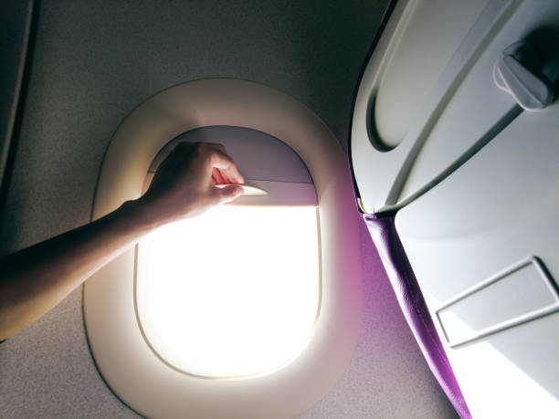 istock Close-up hand open the airplane window 1320113494