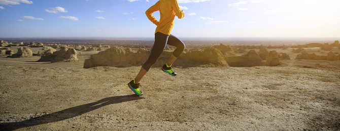 Fitness woman trail runner cross country running on sand desert