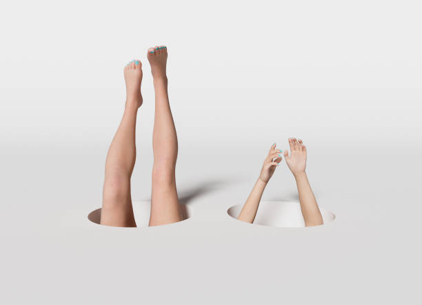 istock Legs and hands out of holes 1320114392
