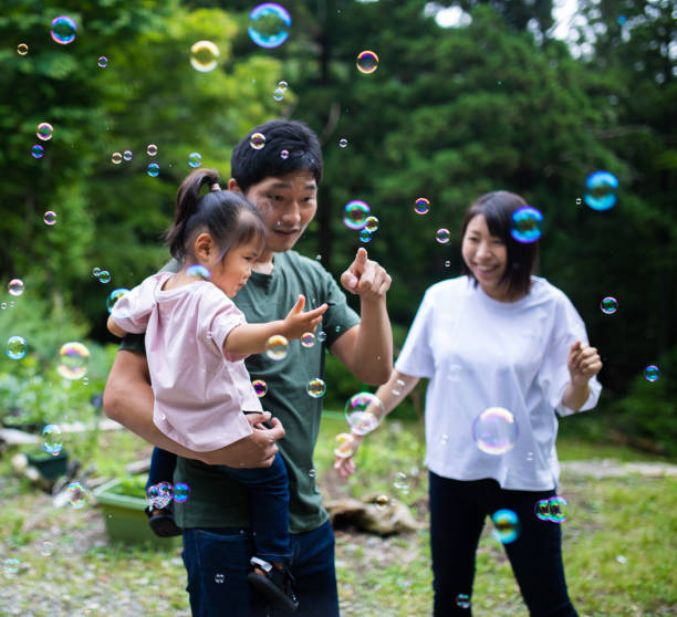 istock Young family playing with bubbles outside 1320114798