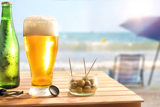 istock Beach bar concept with wooden table with beer and olives 1320117346