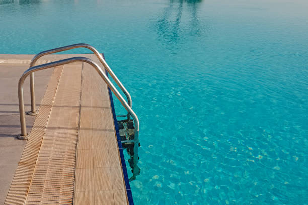 istock Ladder in swimming pool with turquoise water 1320118078