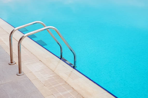 istock Ladder in big swimming pool with blue water. 1320118114