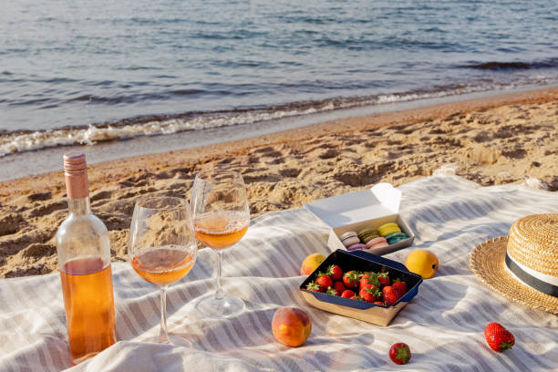 istock Rose wine, peaches and strawberries on the beach. 1320118697