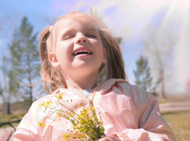 ritratto di bambina con fiori selvatici primaverili all'aperto. i bambini sono un concetto per bambini. - 4 of a kind foto e immagini stock