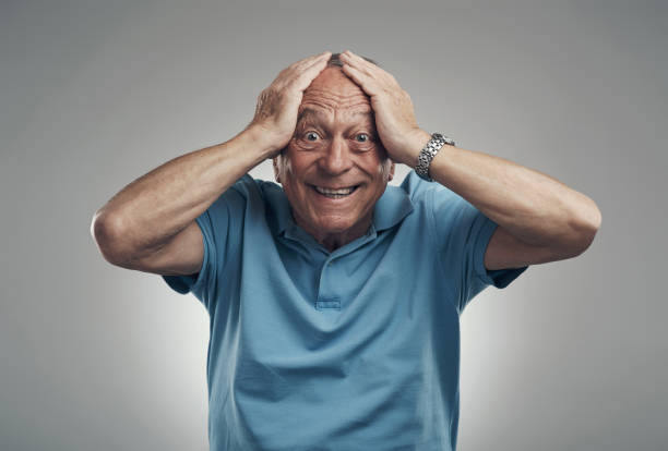 Shot of an older man with his hands on his head in shock in a studio against a grey background I can't believe that just happened wtf stock pictures, royalty-free photos & images