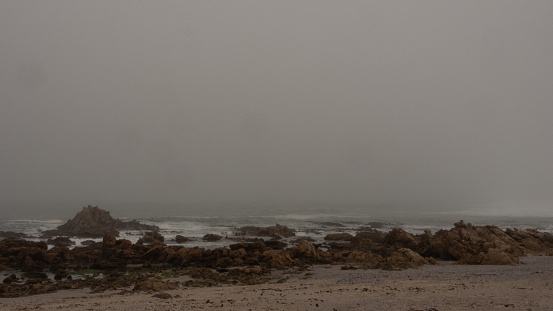 Misty seashore of the West Coast of South Africa. The waves of the Atlantic Ocean is just visible between the mist.