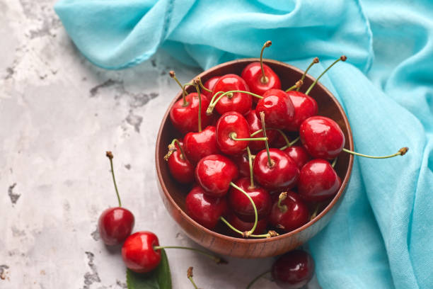 istock Ripe red and yellow cherries in bowl on gray background 1320123231