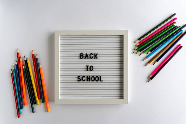 istock Letterboard with Words That Spell Back To School, with colored pencils on a white background, on a white background, horizontal 1320125702
