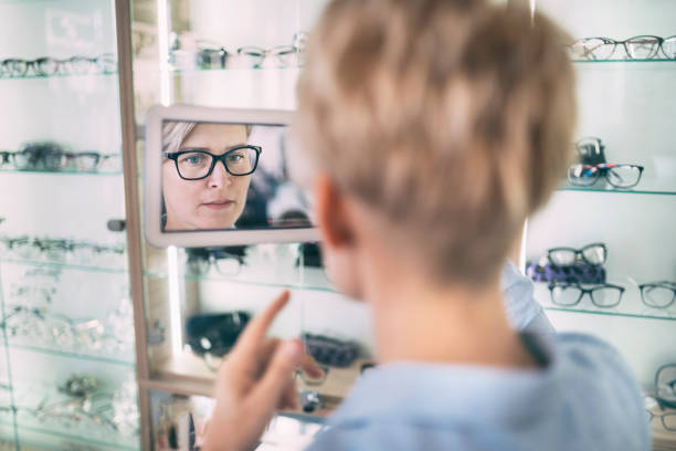 istock Woman choosing new glasses in opticians 1320125803