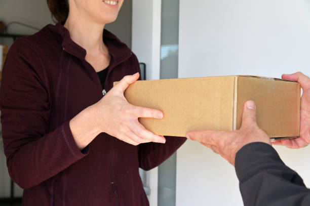 istock Woman receiving a package from a currier 1320127301