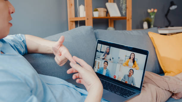 istock Young Asia businessman using laptop talk to colleagues about plan in video call meeting while work from home at living room. 1320127885