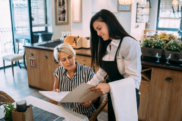 istock Waitress helping a customer to choose a dinner 1320128441