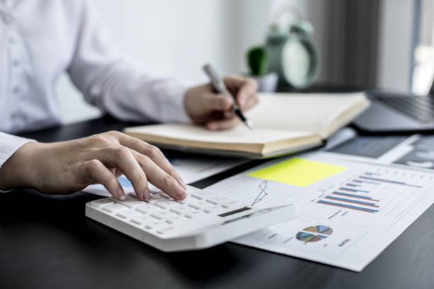 istock An accounting businesswoman pressing the white calculator and taking notes in her notebook, she was examining the company's financial accounts from the documents provided by the finance department. 1320130616