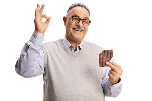 Excited mature man holding a chocolate bar and gesturing a good sign isolated on white background