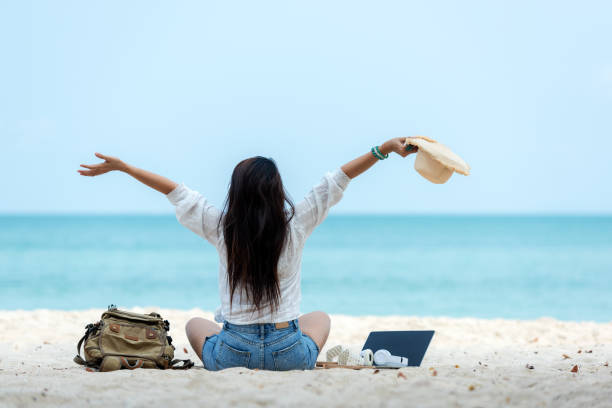 Lifestyle freelance woman raise arms relax after using laptop working on the beach. Asian people success and together your work pastime and meeting conference on internet in holiday. Business and Summer Concept estilo de vida mujer independiente levantar los brazos relajarse después de usar la computadora portátil que trabaja en la playa. el éxito de la gente asiática y juntos su pasatiempo de trabajo y conferencia de reuniones en internet en vacaciones.