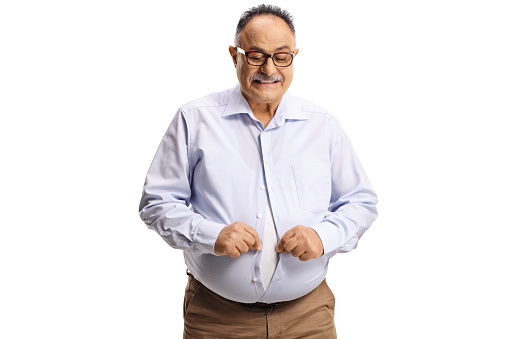 Mature man with a big belly trying to button a shirt isolated on white background