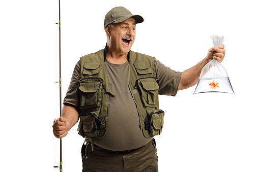 Happy fisherman holding a fishing pole and a golden fish in a plastic bag isolated on white background