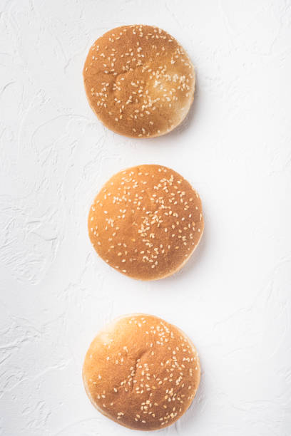 istock Sandwich bun with sesame seeds, on white stone  background, top view flat lay 1320134241