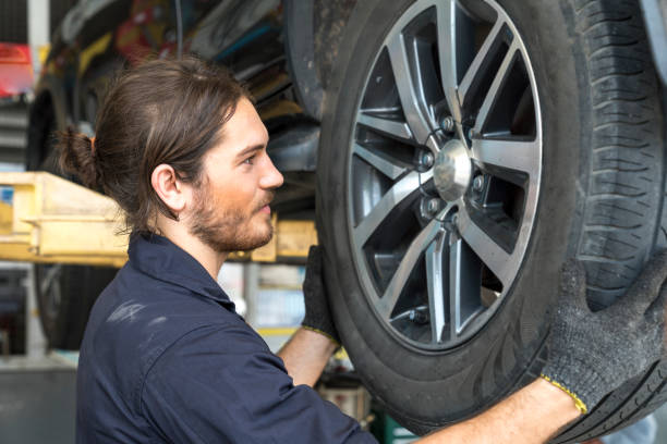 Car repairs. Auto services and Small business concepts. The car service mechanic is replacing the wheels. Removing the wheel. stock photo
