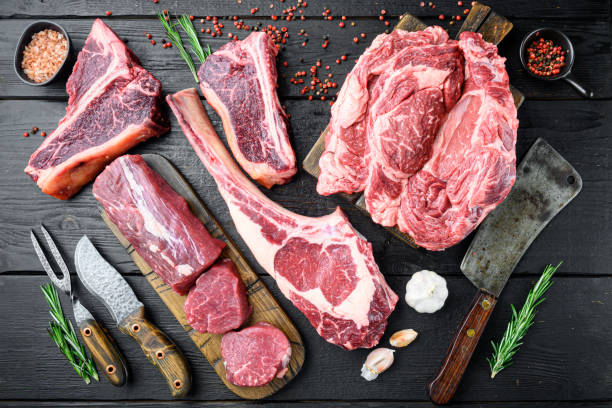 raw beef meat steaks, tomahawk, t bone, club steak, rib eye and tenderloin cuts, on black wooden background, top view flat lay - veal t bone steak raw steak imagens e fotografias de stock