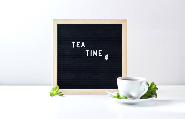 istock Tea time. Black letter board with text on table with glass cup of tea with mint leaves 1320137540