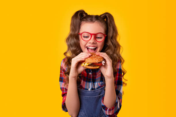 istock Happy girl biting delicious hamburger 1320137737