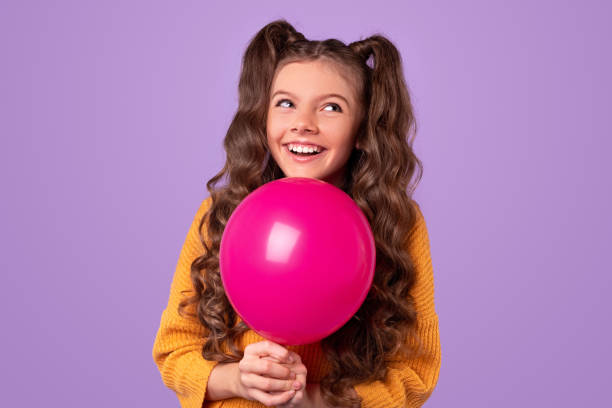 istock Delighted girl with balloon looking away 1320137758