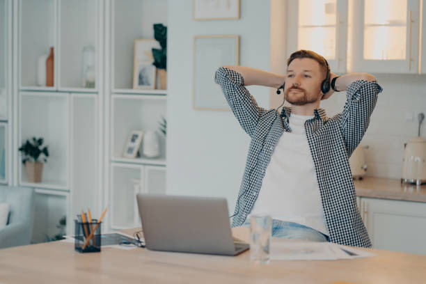 istock Calm young freelancer resting while sitting at his workplace at home 1320138435