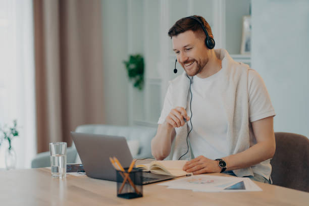 istock Happy man enjoying learning at home and using headset and laptop 1320138513