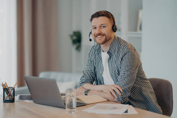 istock Smiling man enjoying remote work at home, looking at camera 1320138756