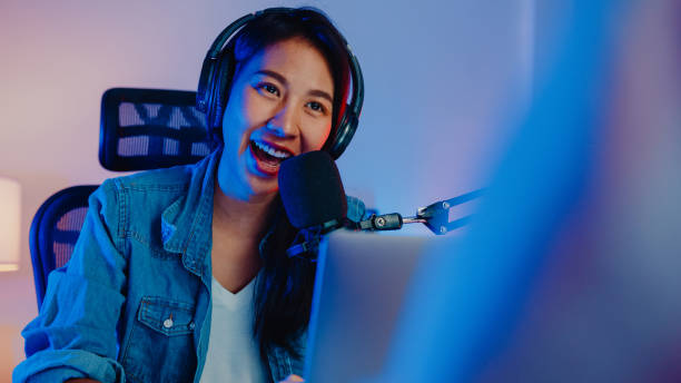 happy asia girl host record podcast używać mikrofonu nosić słuchawki z laptopem wywiad rozmowy gości na treści w jej studio domu w nocy. - vip room zdjęcia i obrazy z banku zdjęć