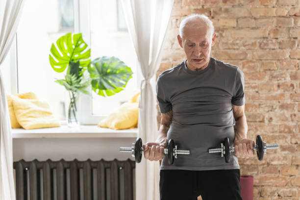 istock Elderly man exercising with a dumbbells during his workout in home gym 1320139819