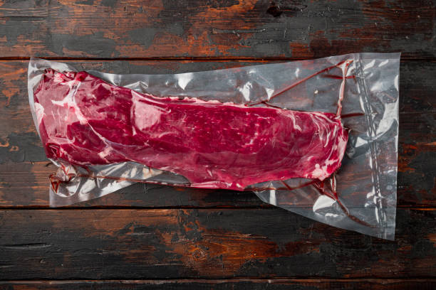 istock Fillet beef vacuum bag for sous vide, on old dark  wooden table background, top view flat lay 1320140310