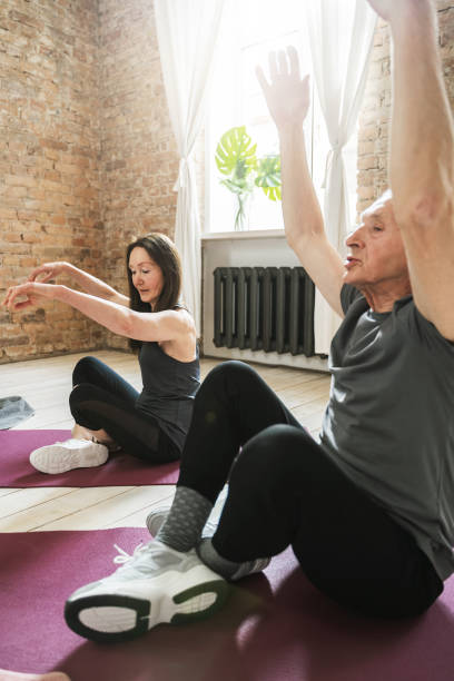 istock Active elderly people sitting on a exercising mats during fitness workout 1320141023