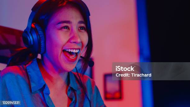 Happy asia girl gamer wear headphone competition play video game online  with smartphone colorful neon lights in living room at home. Esport  streaming game online, Home quarantine activity concept. 3652236 Stock Photo